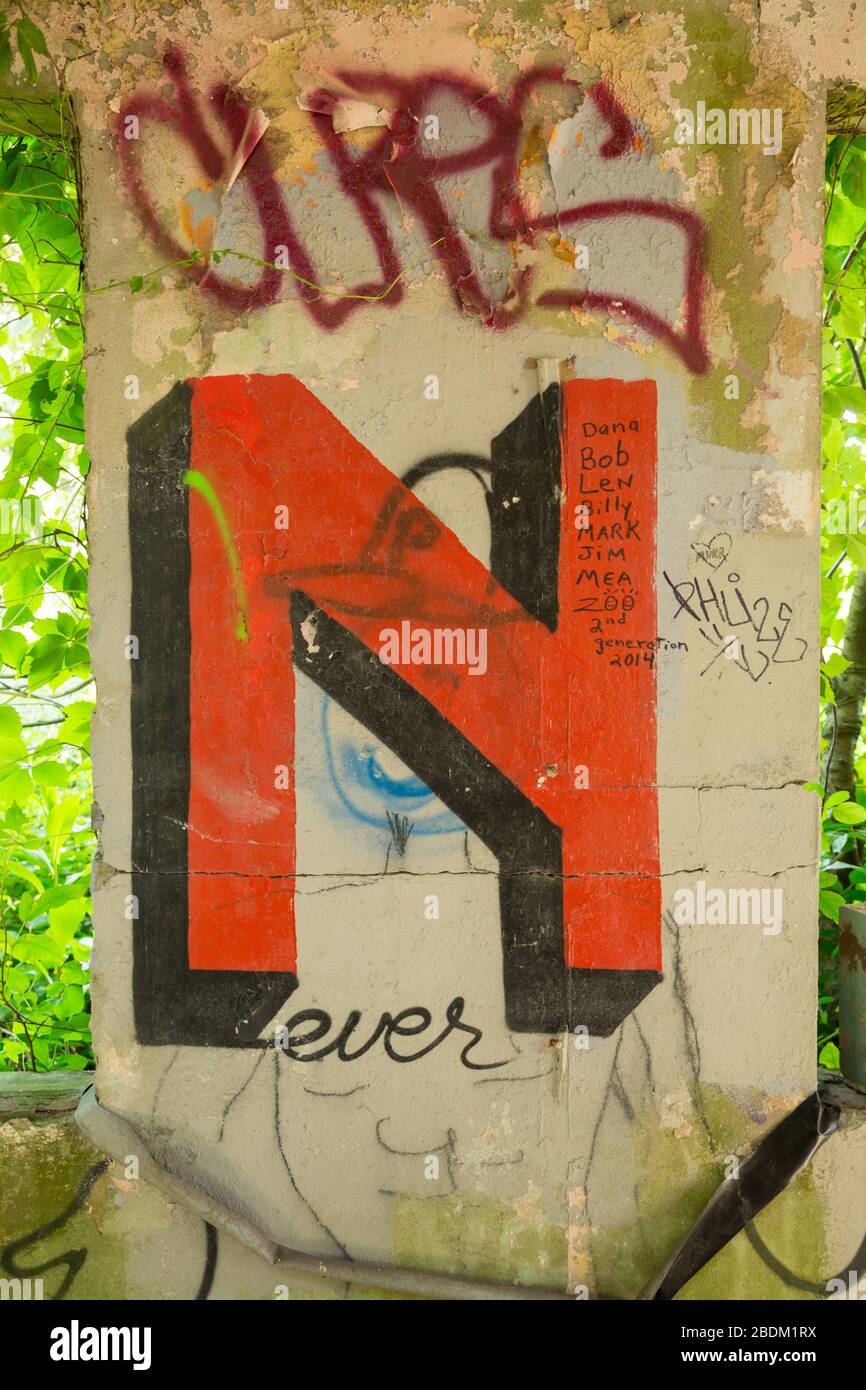 The letter N spray painted in red on a wall. Stock Photo