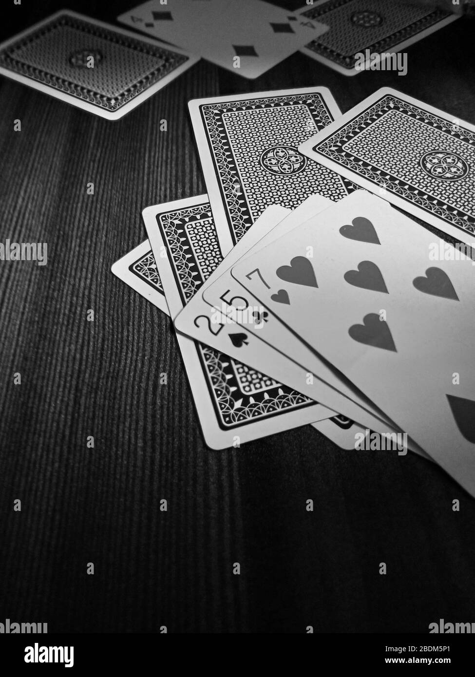 Playing cards in wooden table black and white enjoy your game Stock