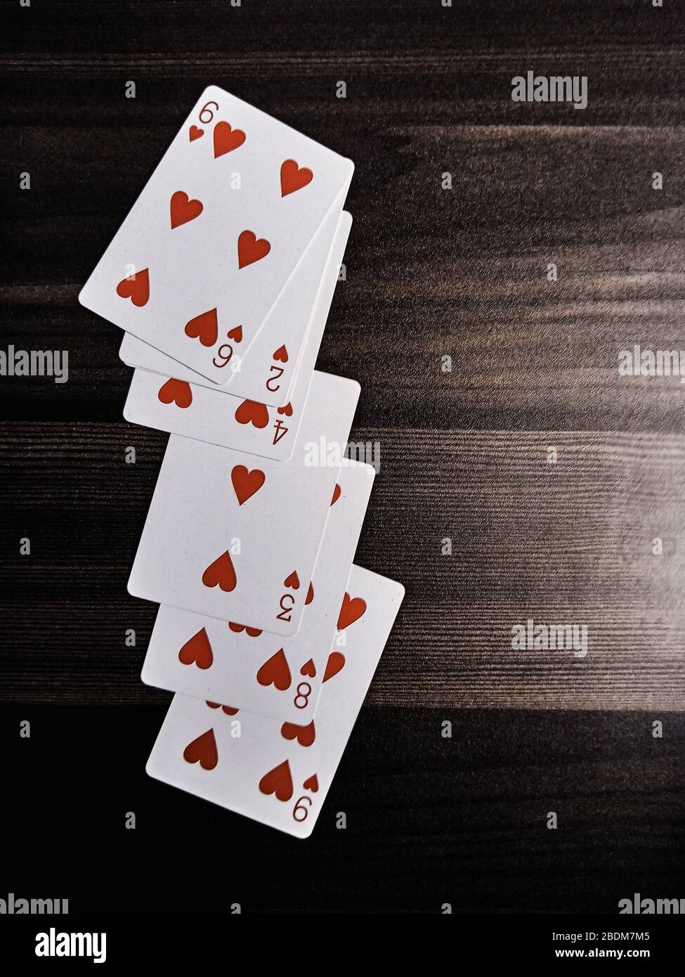 Playing cards in wooden table black and white enjoy your game Stock Photo