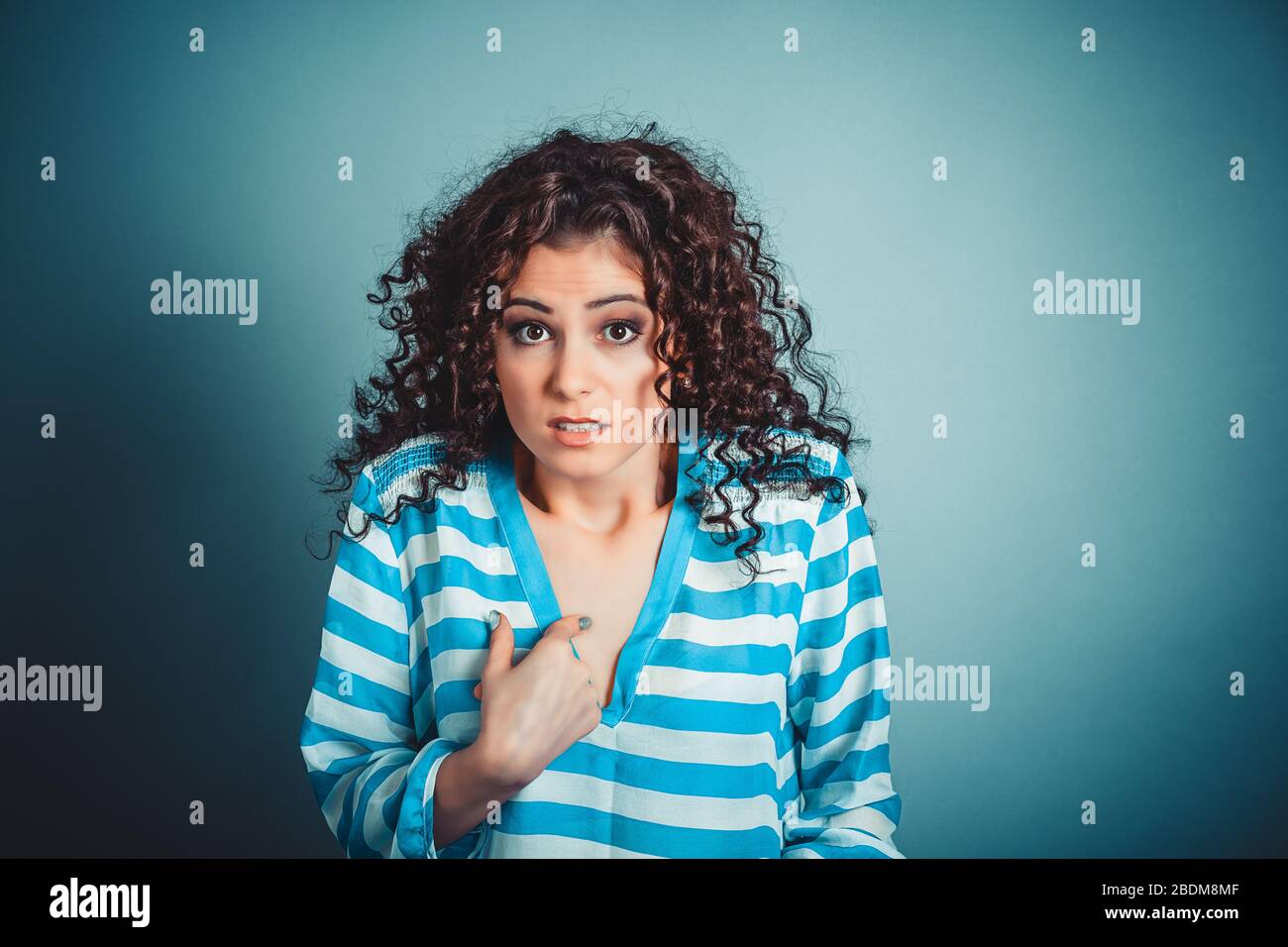 Me? Portrait of angry unhappy annoyed young woman getting mad asking question you talking to me, you mean me? really? Isolated blue wall background. N Stock Photo
