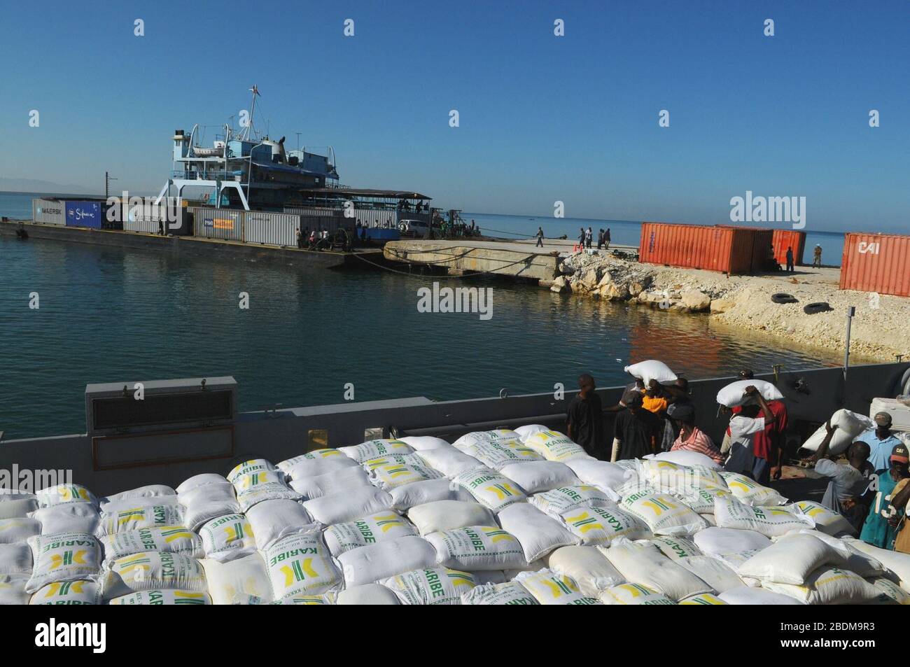 Haitian citizens unload relief supplies Stock Photo