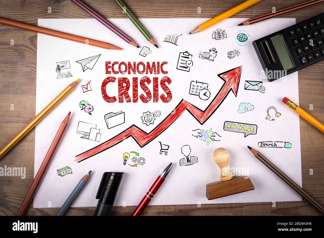 Economic Crisis. Arrow with icons. Stamp and pencil, calculator on white piece of paper Stock Photo