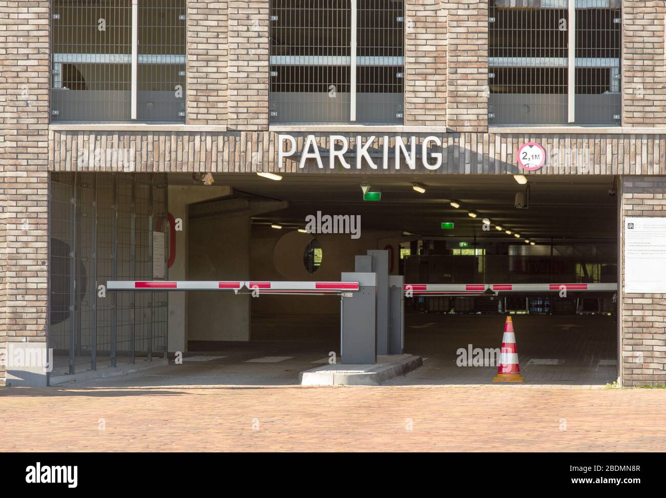 Entrance to a parking garage with closed barriers where cars are parked Stock Photo