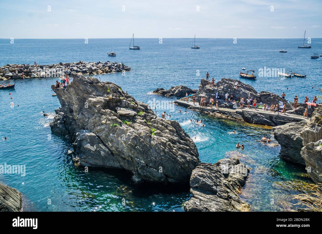 swimming in the rock fringed harbour of Manarola in the Cinque Terre, Ligurian Riviera di Levante, Liguria, Italy Stock Photo