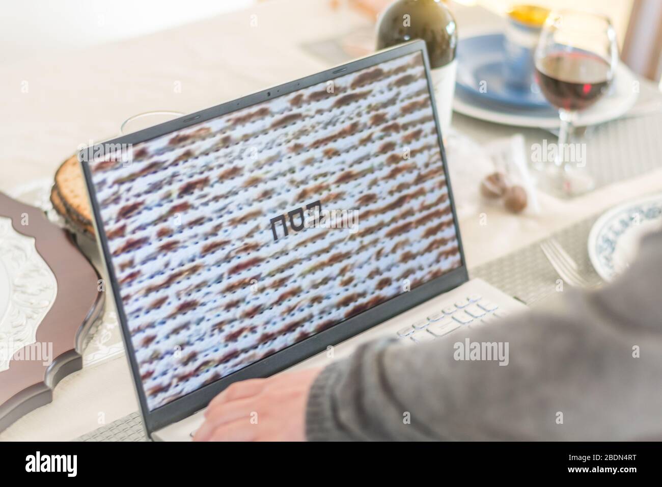 Isolated presentation on a laptop during the Passover Seder dinner mixing new traditions with old traditions- Israel Stock Photo