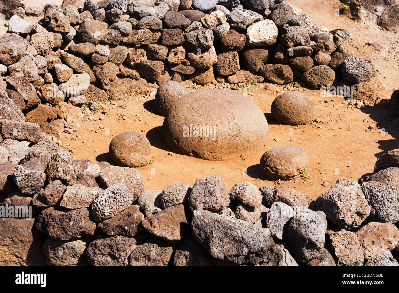 Navel of the World, a large round stone surrounded by rock wall on Easter Island. Four surrounding stones represent the four cardinal directions. Stock Photo