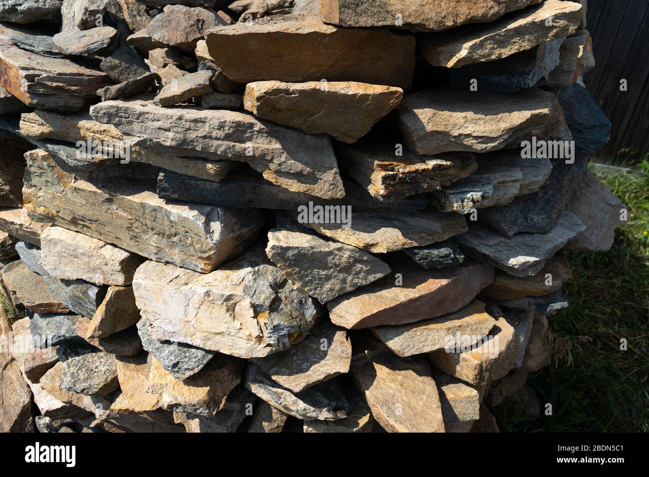 Stone natural flagstone piled in a pile. Natural stone flagstone, laid in uneven rows