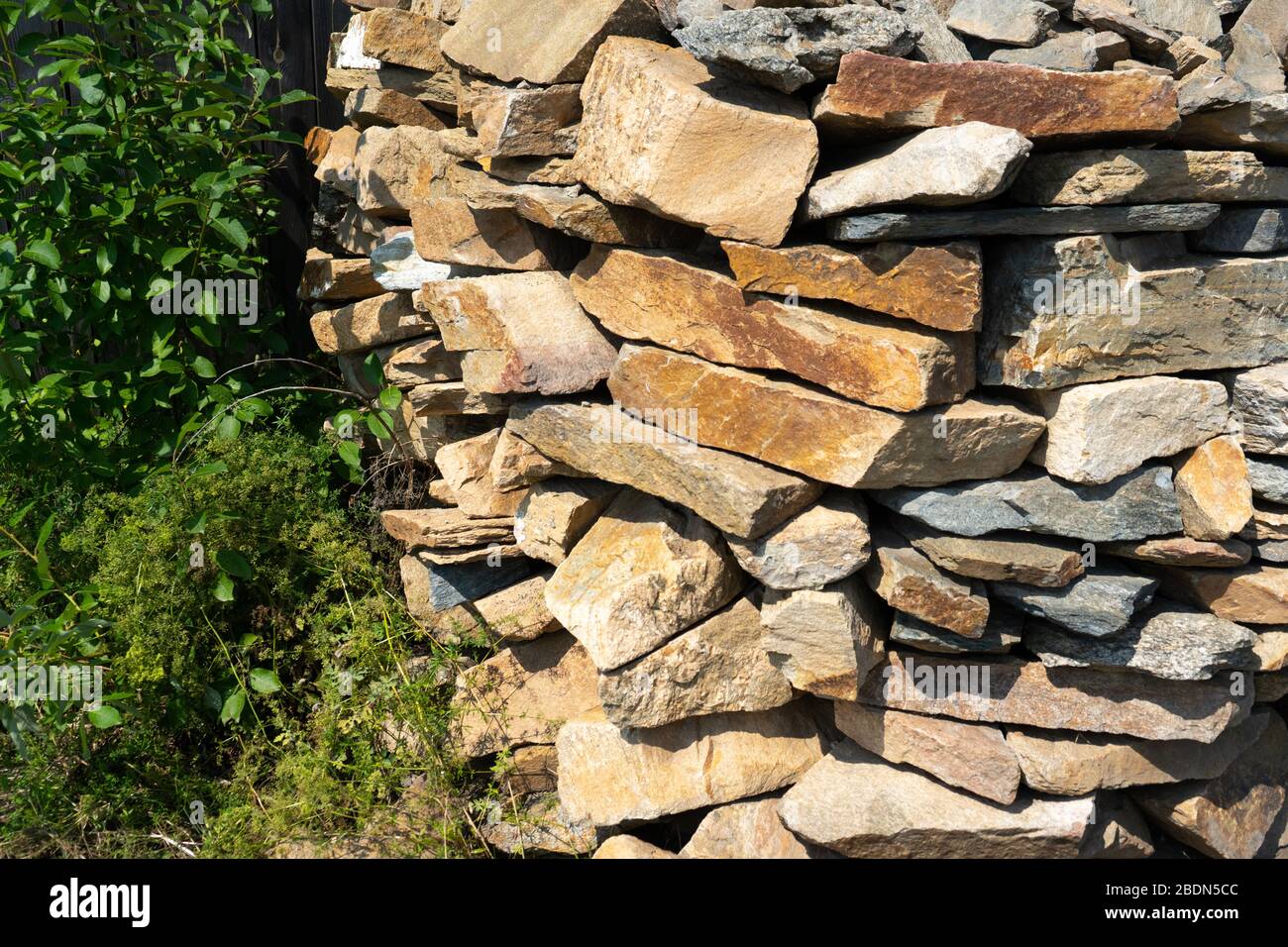 Stone natural flagstone piled in a pile. Natural stone flagstone, laid in uneven rows