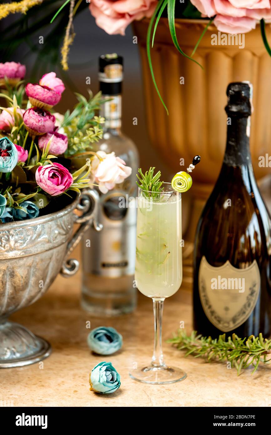 glass of alcoholic drink and a vase of flowers Stock Photo Alamy