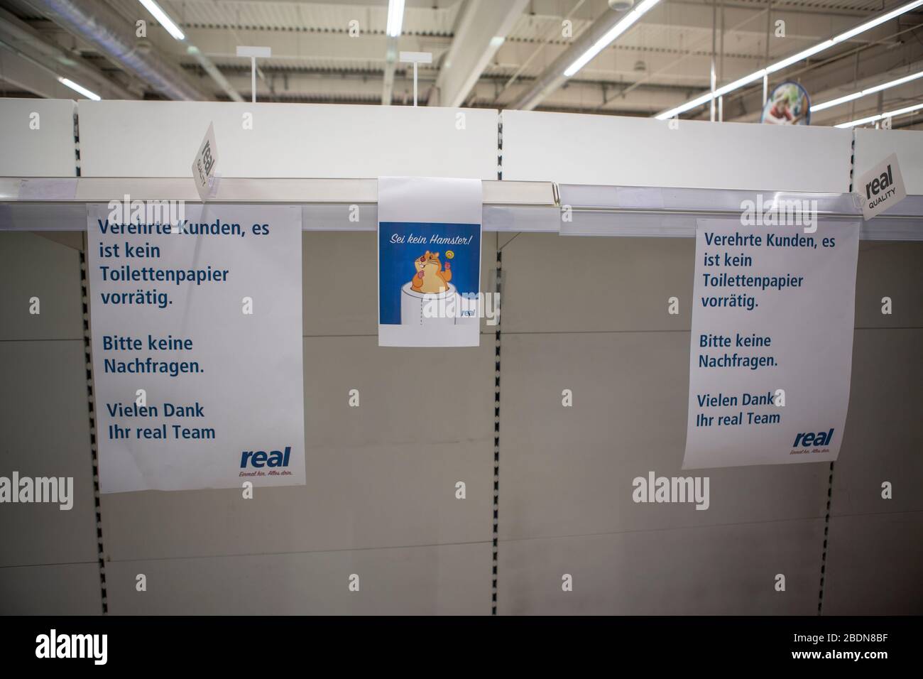 Leere Regale und Schilder, daß Toilettenpapier ausverkauft ist. Während der Corona-Pandemie hat auch das Kaufhaus REAL durch die Hamsterkäufe keine Vo Stock Photo