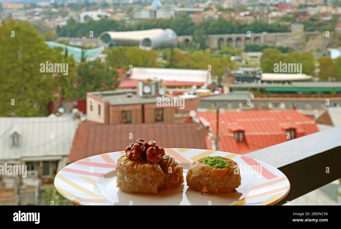 Closeup a Plate of Two Baklava Pastries with Blurry City View in the Backdrop Stock Photo