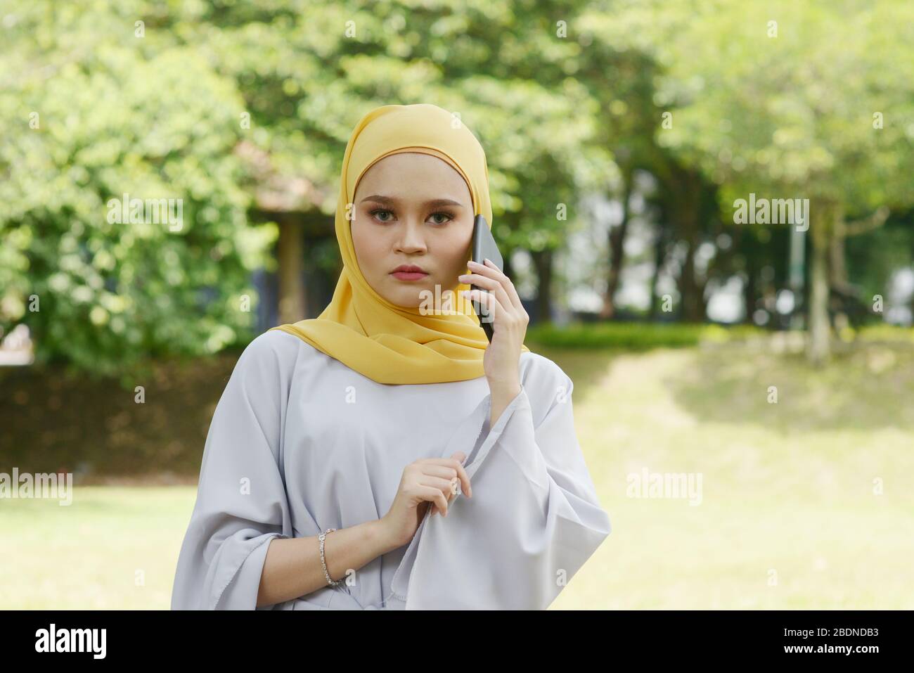 Muslim women received scam call, phishing alert concept. Stock Photo