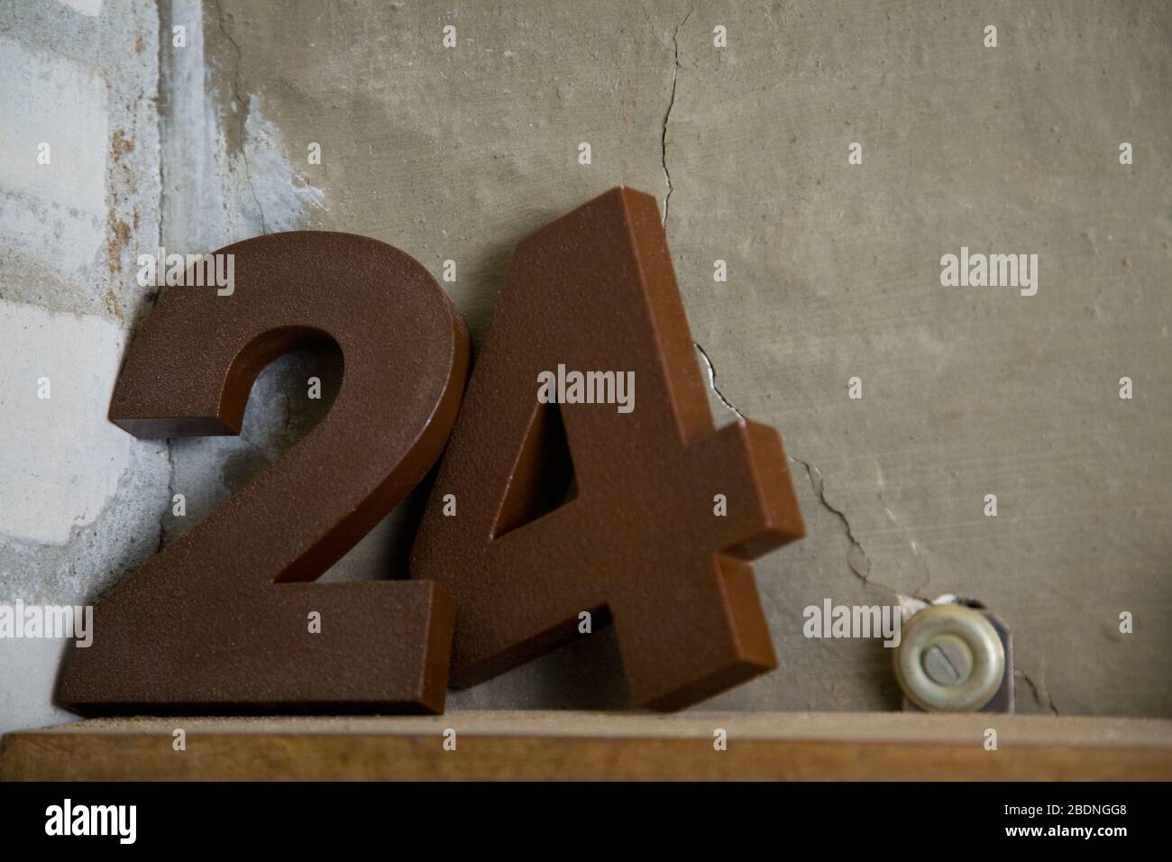 The number 24 as a metal number on a shelf Stock Photo