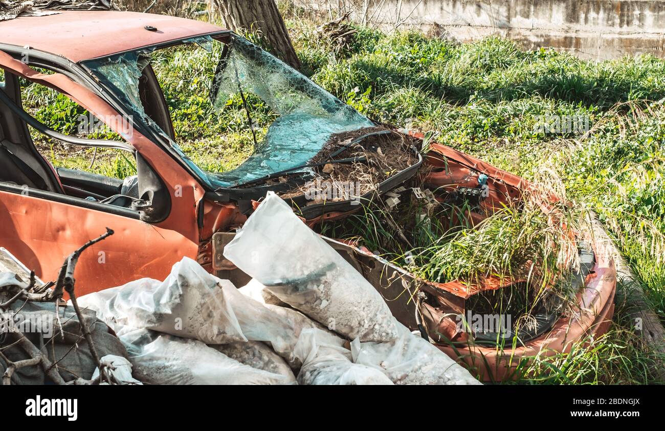 the ruins of an abandoned car and garbage bags Stock Photo Alamy