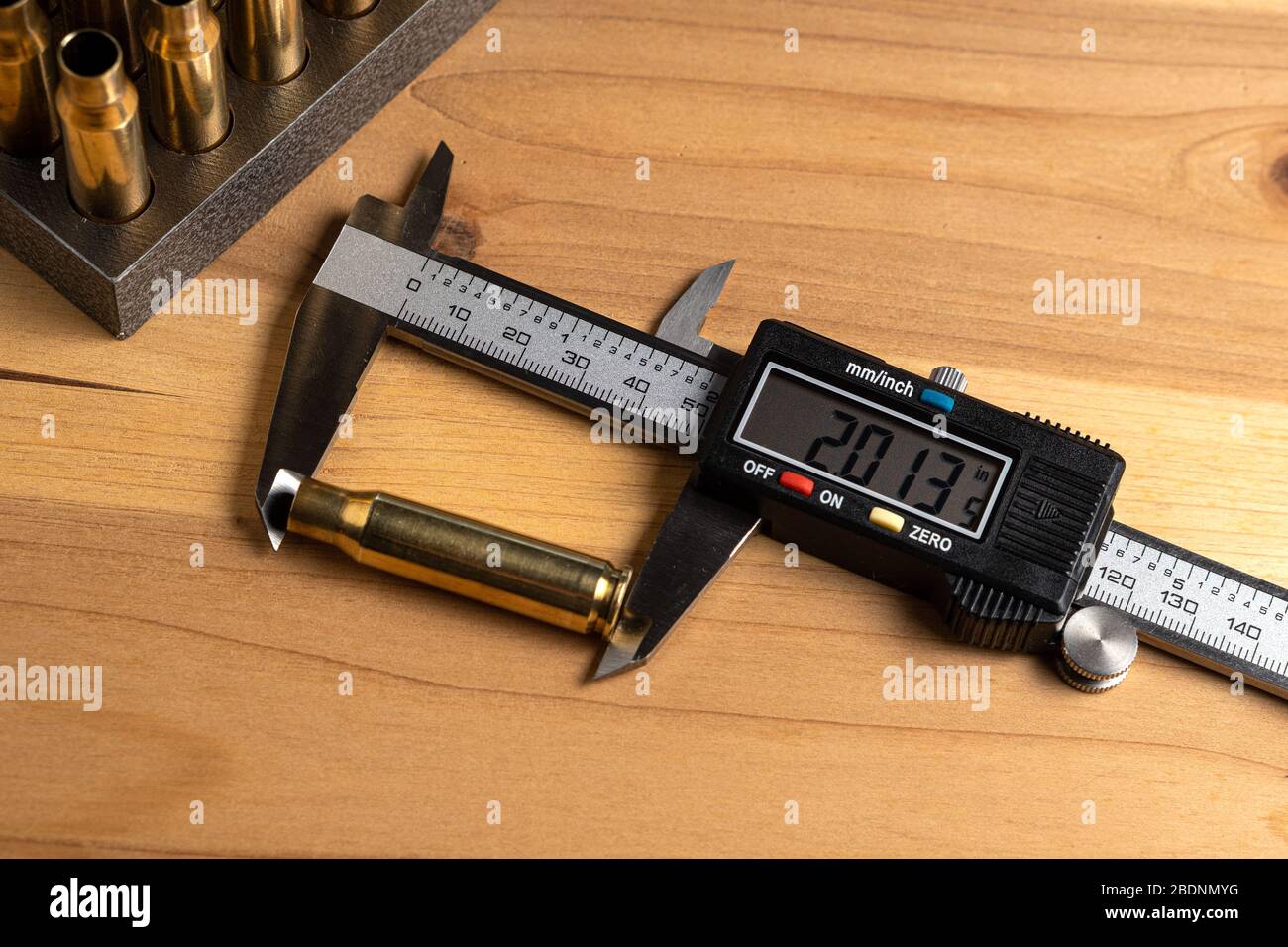 Production of cartridges for a rifle, reload. Measurement of the empty cartridges with a caliper. Top view Stock Photo