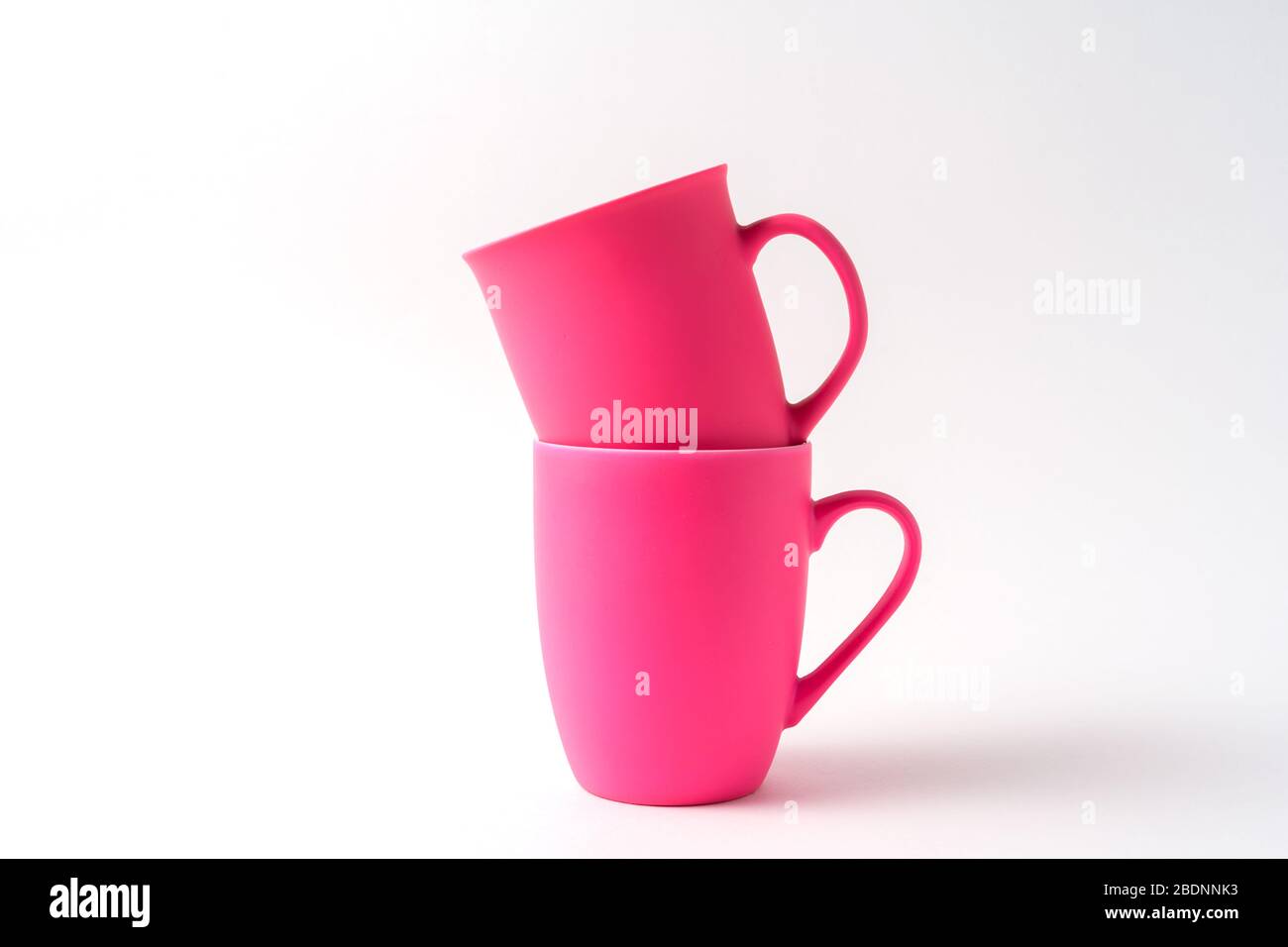 Stack with pink mugs isolated on white background, front view. Stock Photo