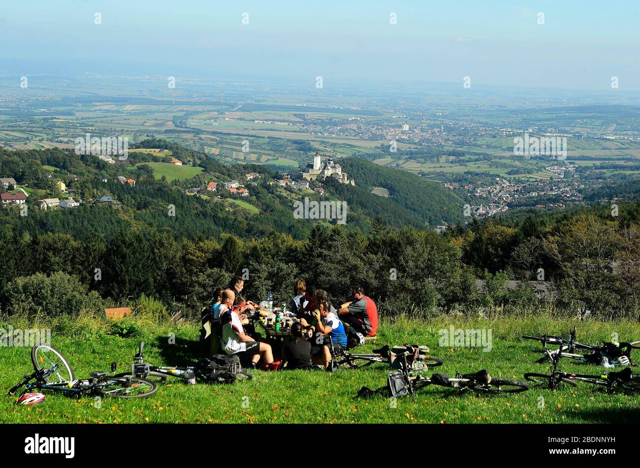 Forchtenstein, Austria - September 28, 2014: Group of unidentified cyclists rest in Rosalia mountains with view to village and castle Forchtenstein in Stock Photo