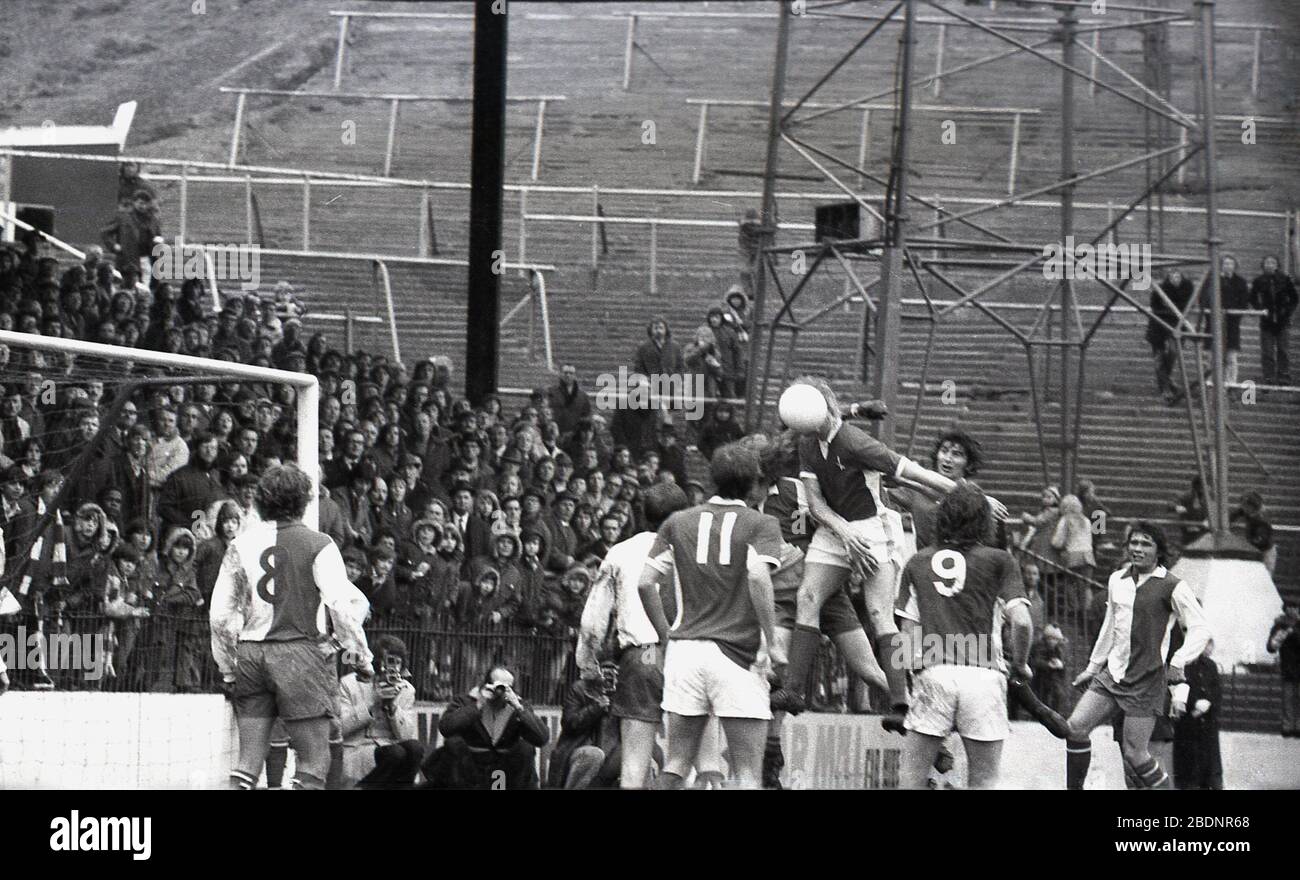 1973, goal mouth action at the Valley, home of Charlton Athletic FC. In the picture, the steep terraces and 'safety' metal barriers of the famous East Terrace. The name 'valley' came from the earth mounds surrounding the pitch which were turned into concrete terracing. By the 1930s, the 'Valley' was one of England's biggest and the massive East Terrace, with capacity at one point for up to 20,000 fans, the largest in the country. In 1979 capacity in the East Terrace was reduced to 10,000 and in 1984 the GLC applied to close it altogether as the required repairs had not been undertaken. Stock Photo