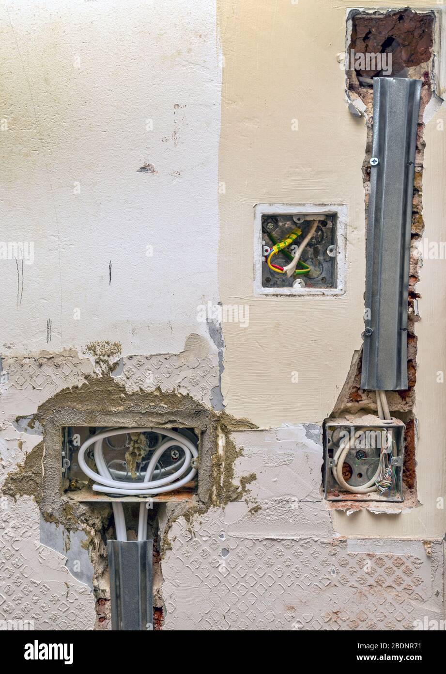 Installation of electrical wiring into kitchen wall Stock Photo
