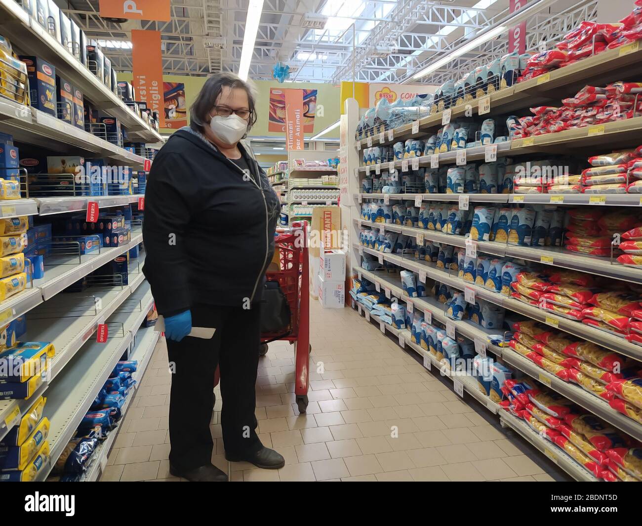 A woman buys food and drinks inside a large shopping center.Wears mask and gloves as required by government for prevention from covid-19 . Stock Photo