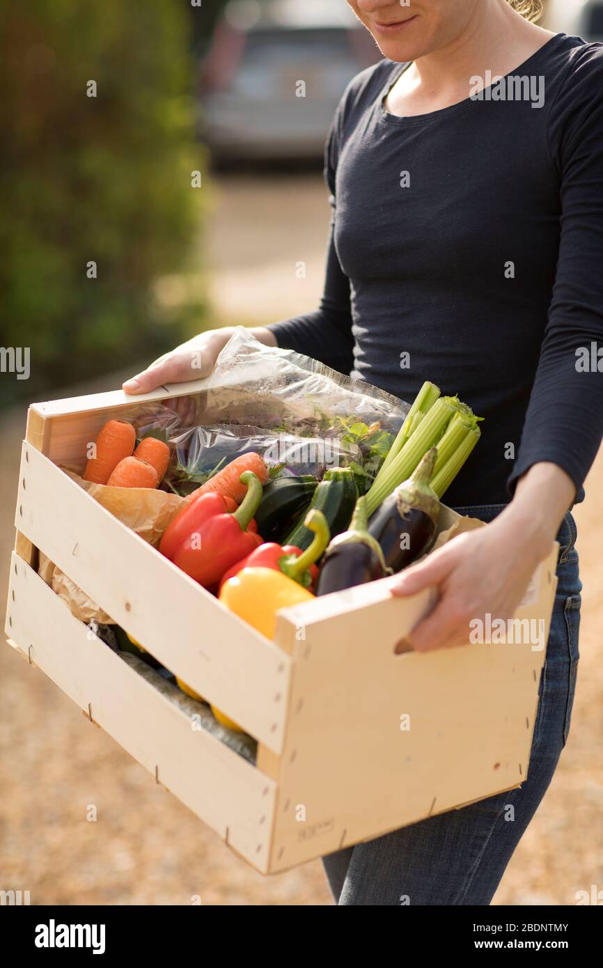 A woman receives a vegetable box delivery at a residential home in Guildford Surrey, U.K. on Wednesday, April. 8, 2020. Photographer: Jason Alden Stock Photo