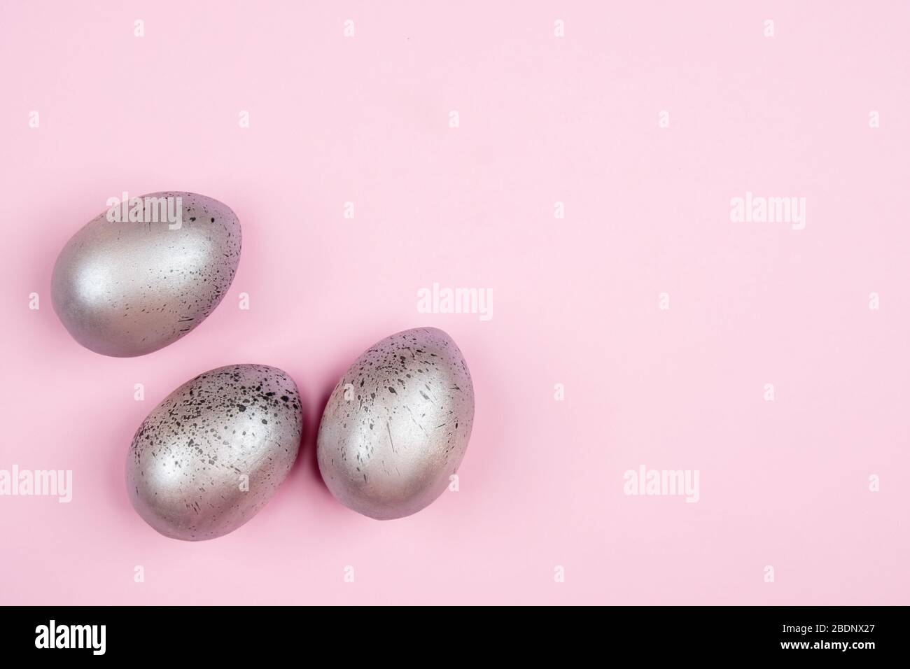 Three easter silver eggs on pink background with copyspace Stock Photo
