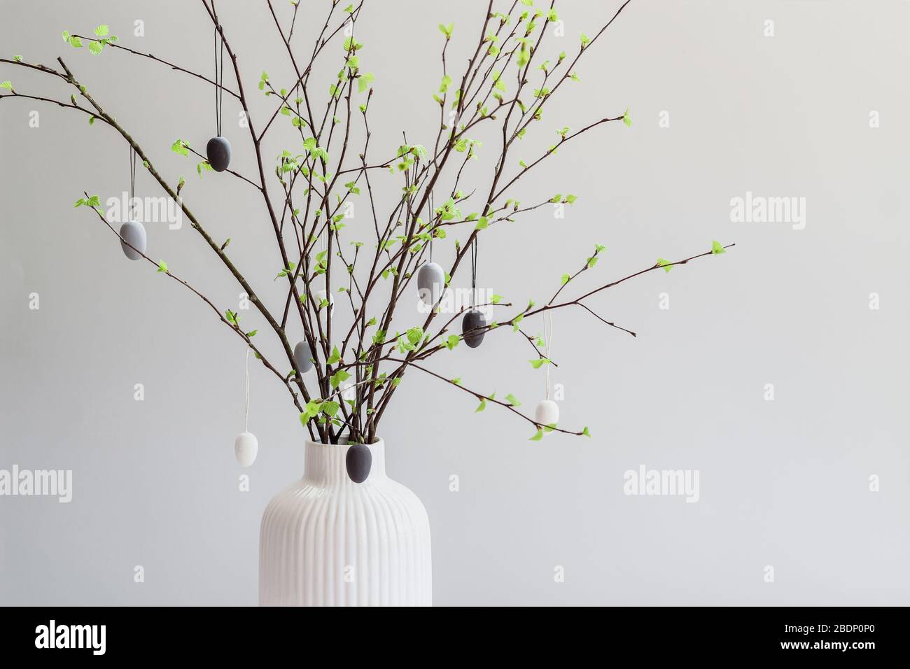Birch tree branches decorated with white and gray painted eggs. Easter tree. Postcard with a copy space Stock Photo