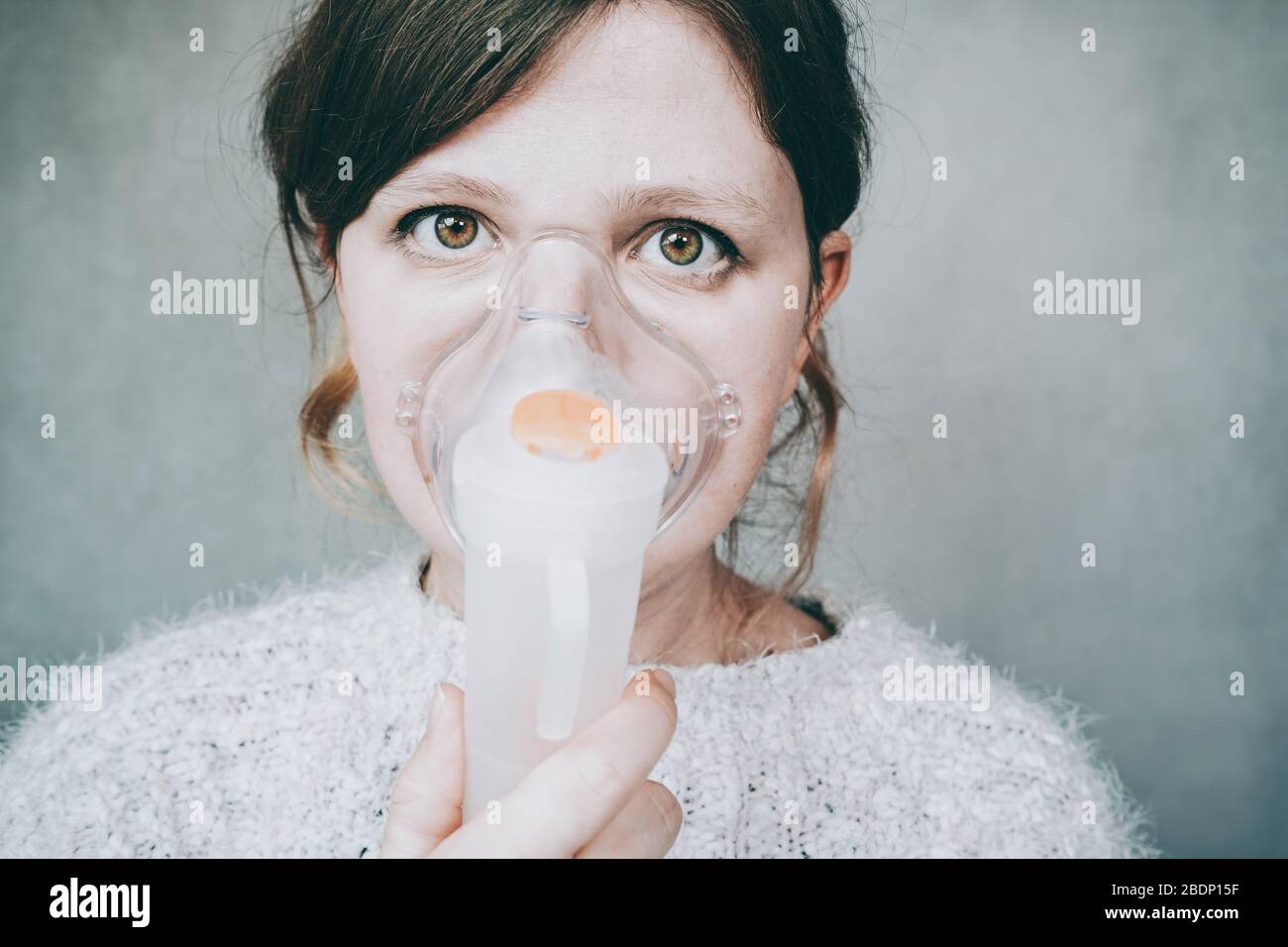 Young woman using a breathing mask Stock Photo - Alamy