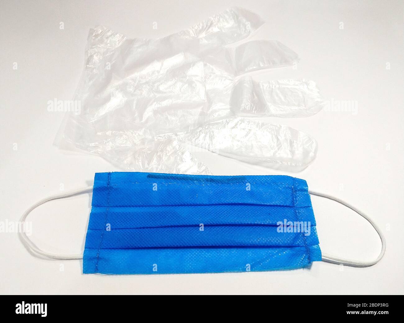 Surgical mask and disposable transparent clear plastic gloves for protection against corona virus, COVID-19 Stock Photo