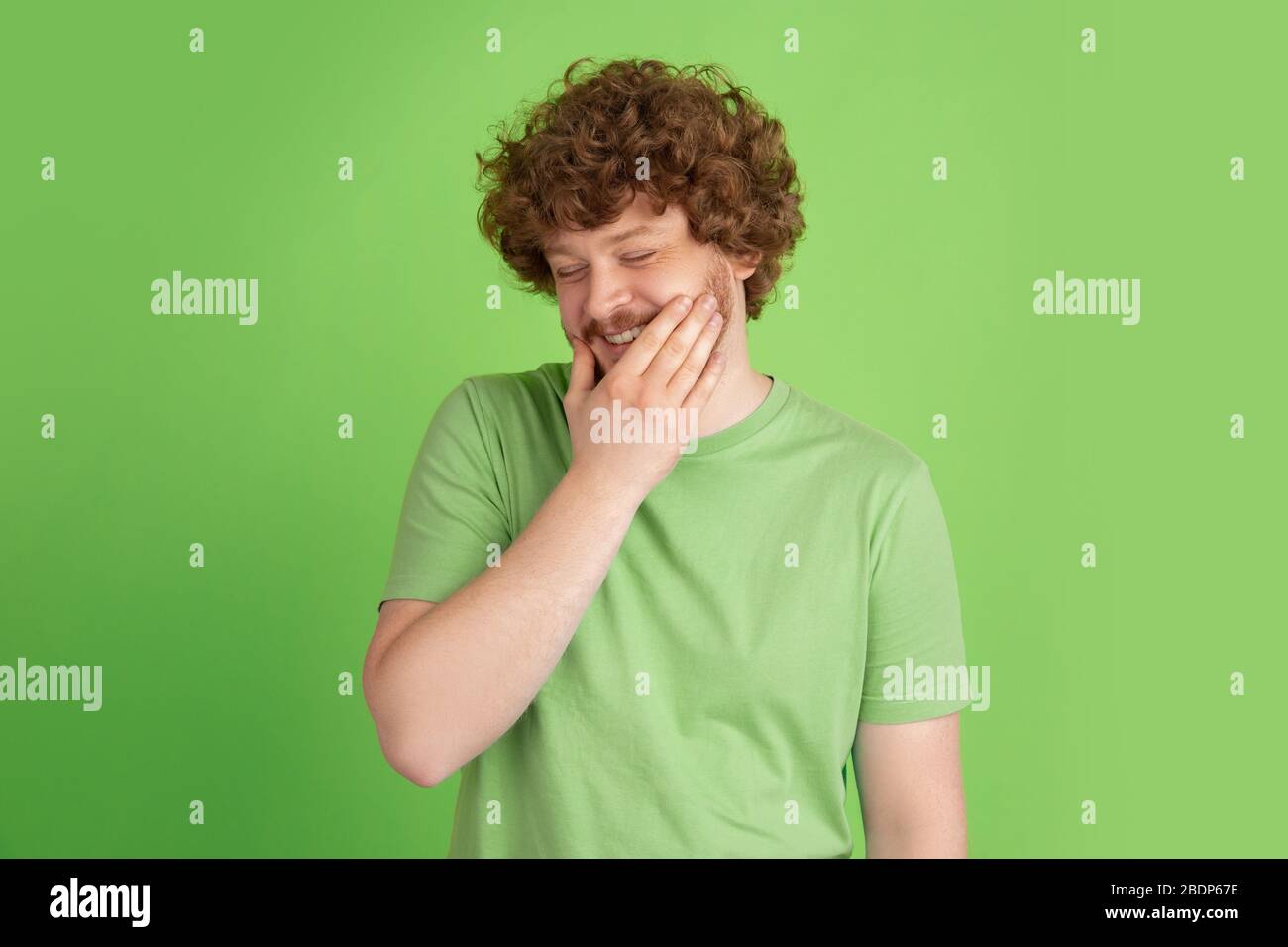cute-embarrassed-caucasian-young-man-s-monochrome-portrait-on-green