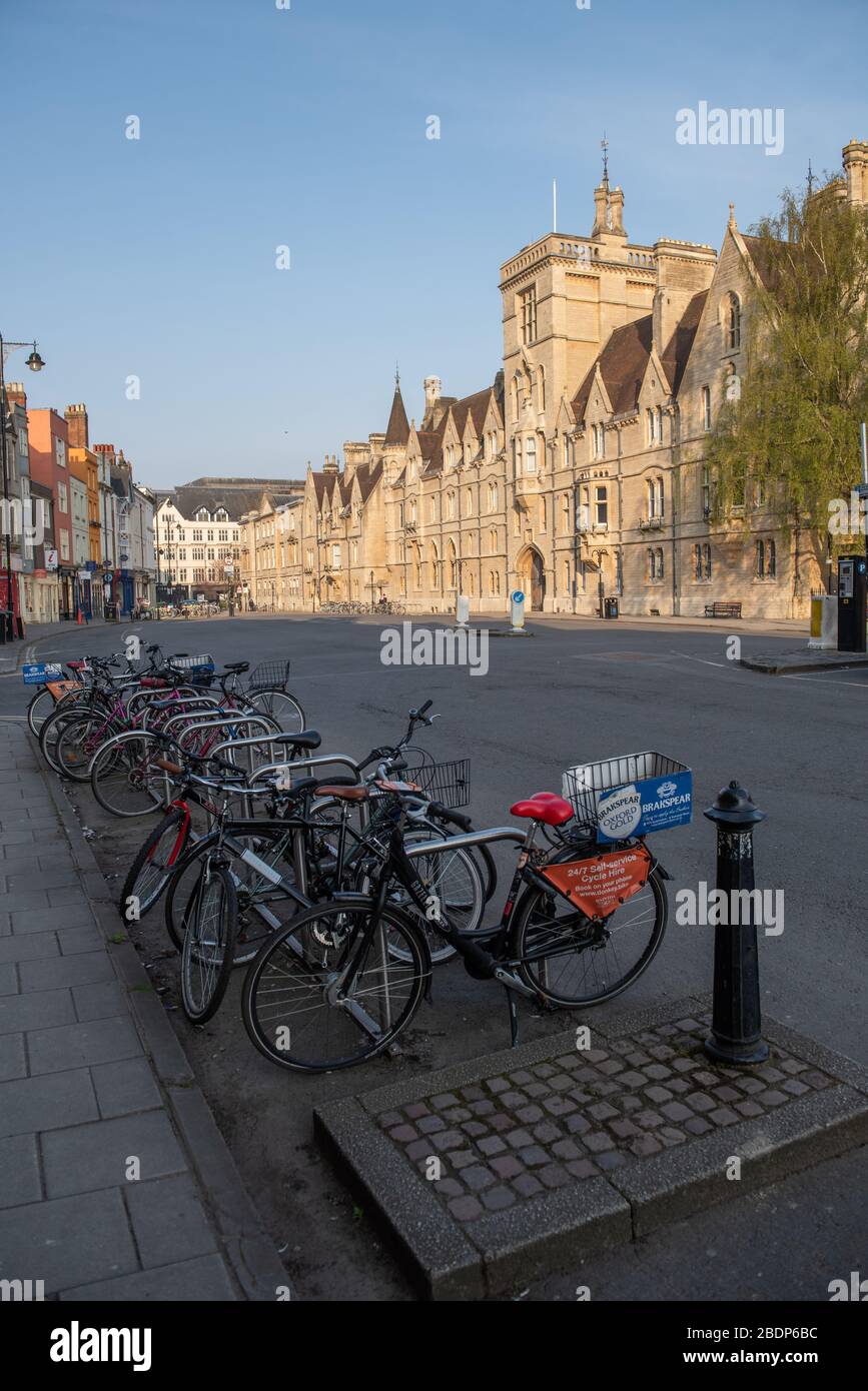 Bikes stand silently in a deserted Broad Street, Oxford.  Balliol College behind Stock Photo