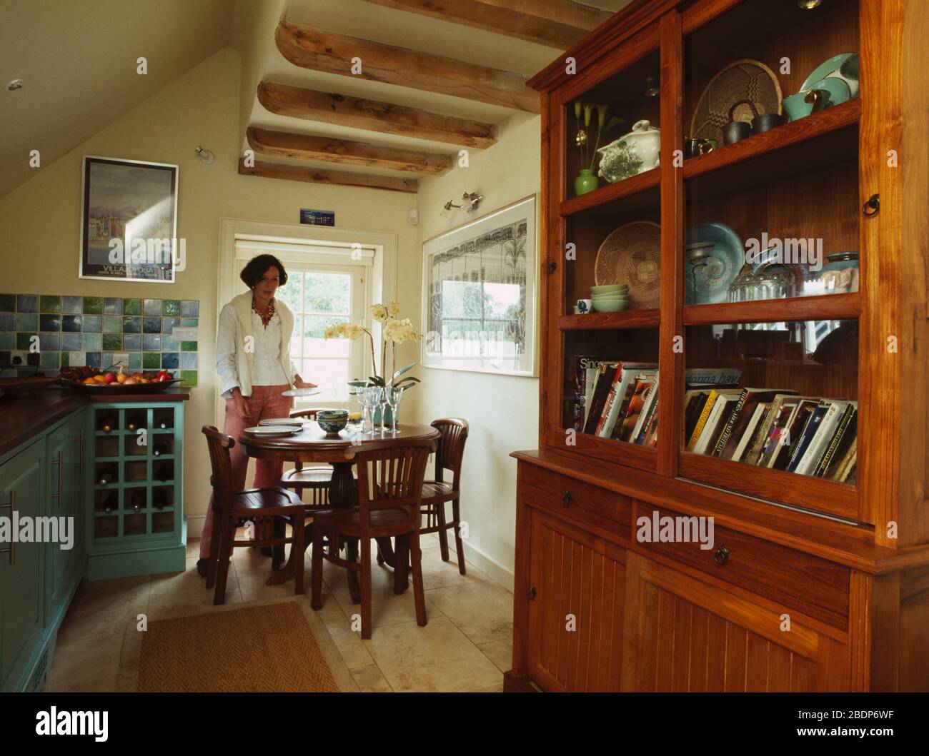 Woman setting table in kitchen FOR EDITORIAL USE ONLY EDITORIAL USE ...