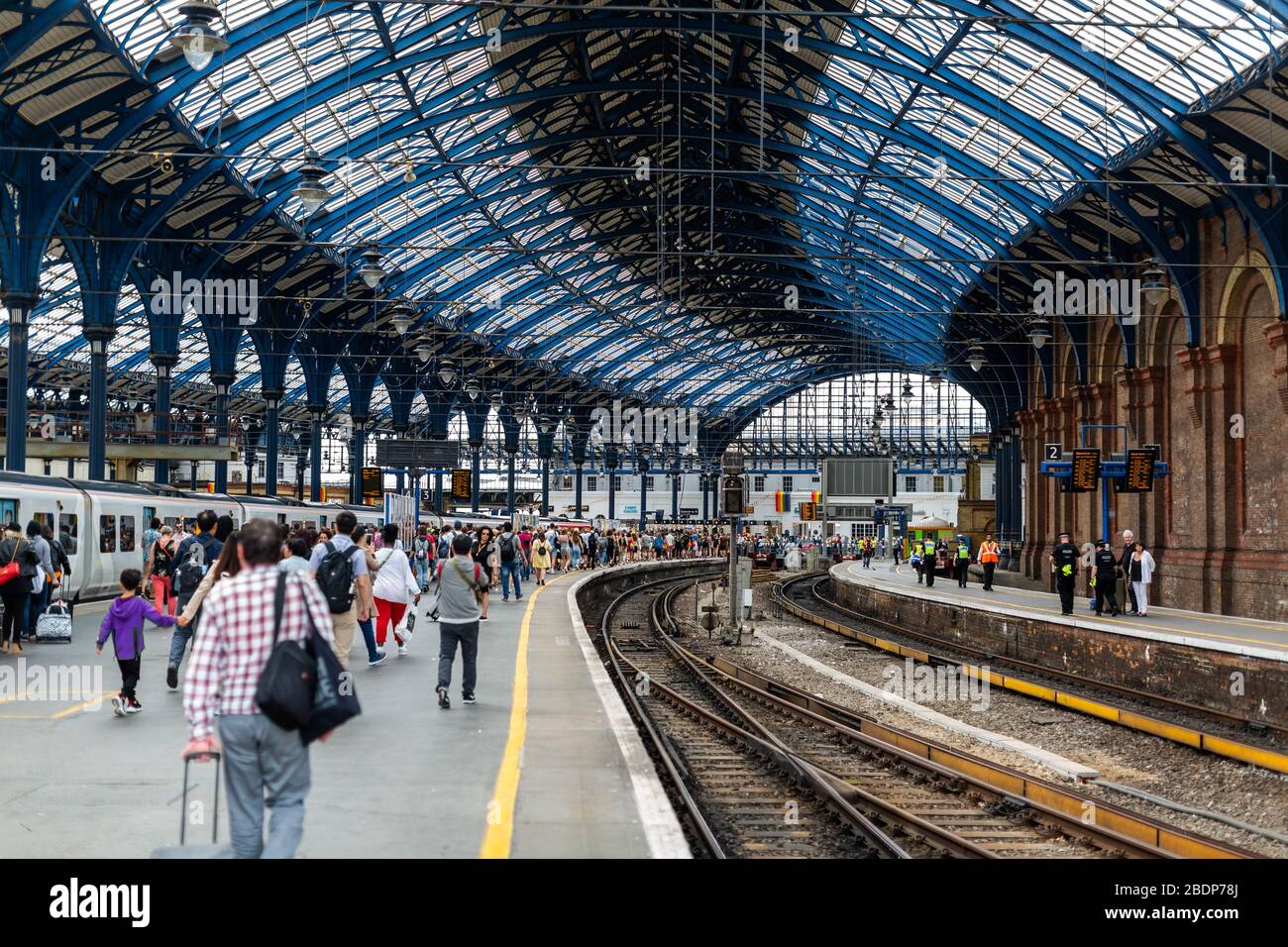 Travellers disembark at Brighton Railway station. Located on the English Channel, Brighton is popular with those looking for a day trip to the beach. Stock Photo