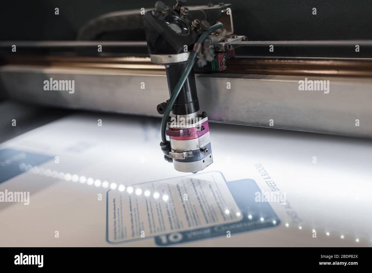 Electrical engineer repairs a laser cutting head on large CNC computer
