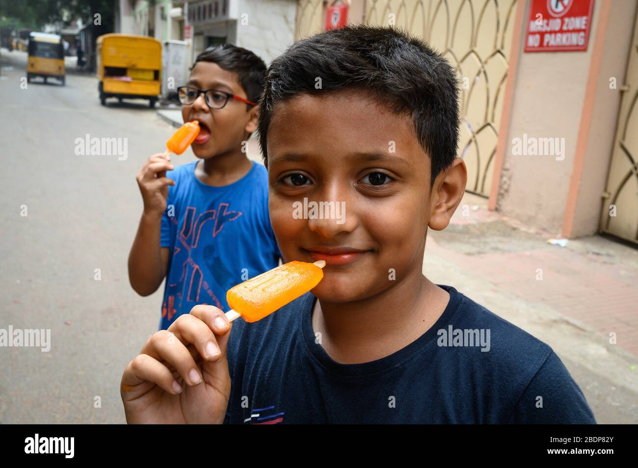 Two boys eating popcycles, Chennai, India Stock Photo