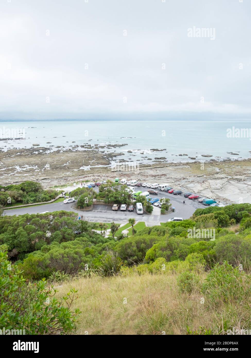 The rocky shore and coastline and landscape  at Point Kean Kaikoura New Zealand on a grey day with a view of the car park area. Stock Photo