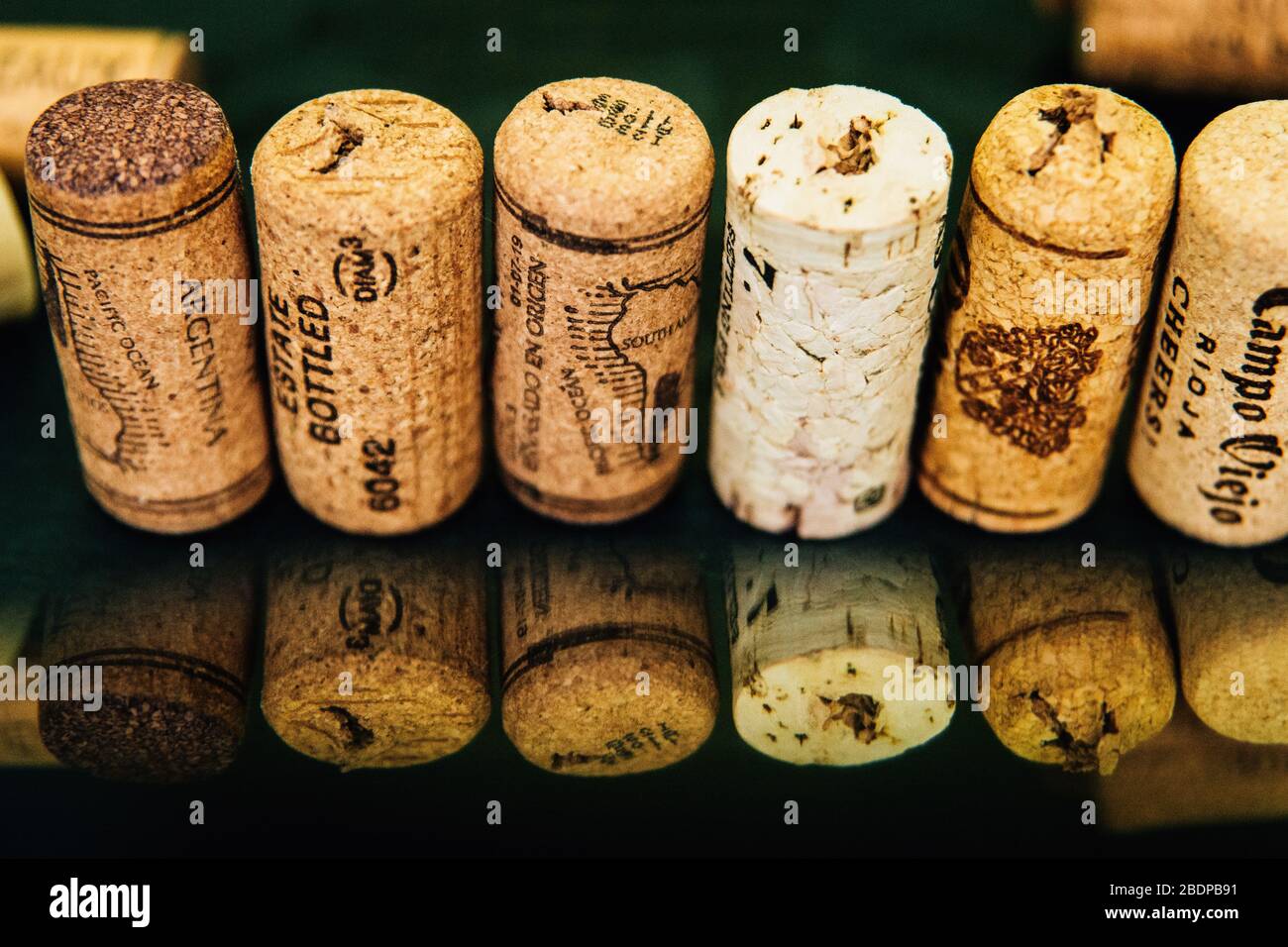 Corks lined up on a black background with reflection. Stock Photo