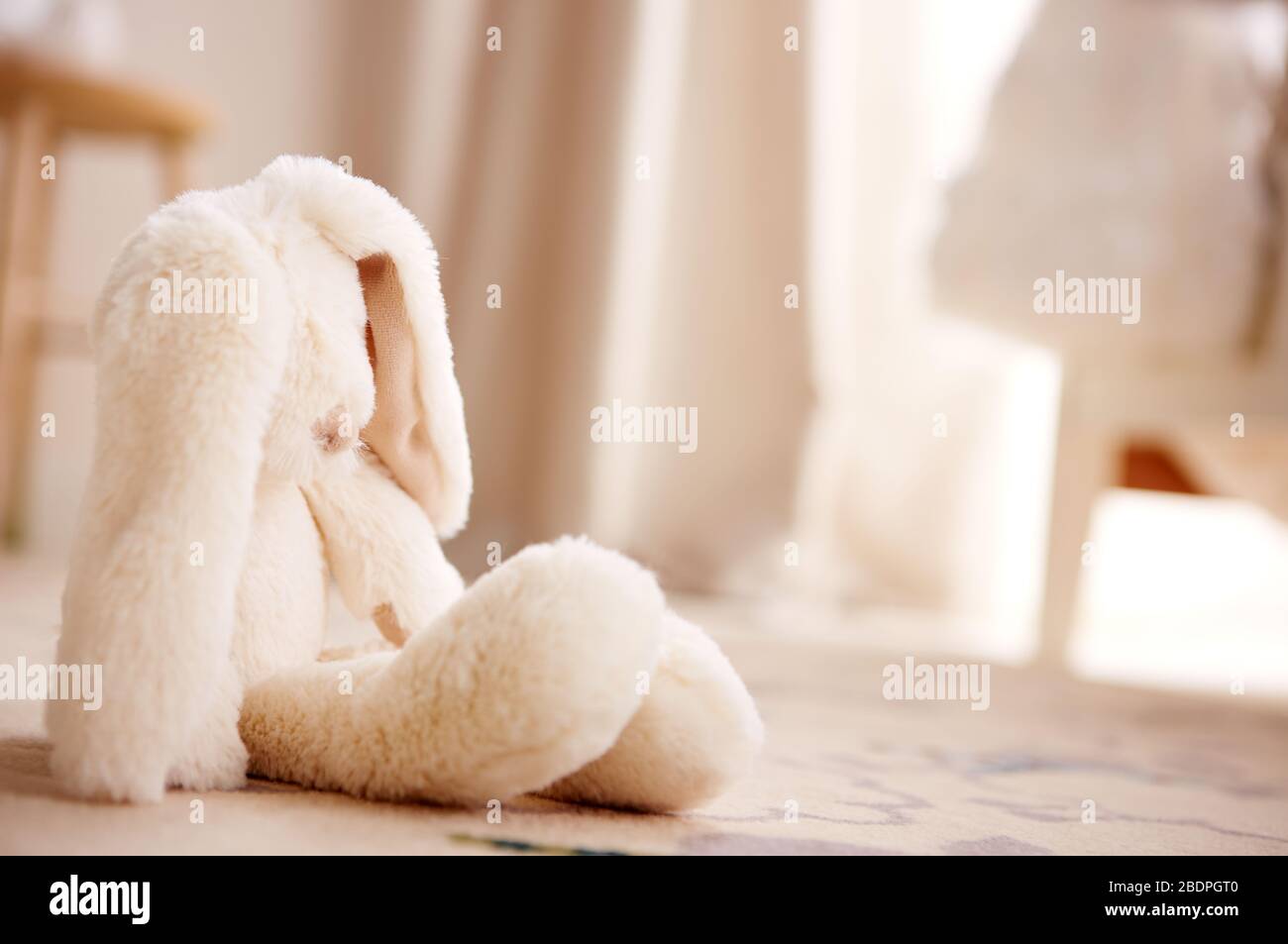 Image of a stuffed soft toy bunny on the floor Stock Photo