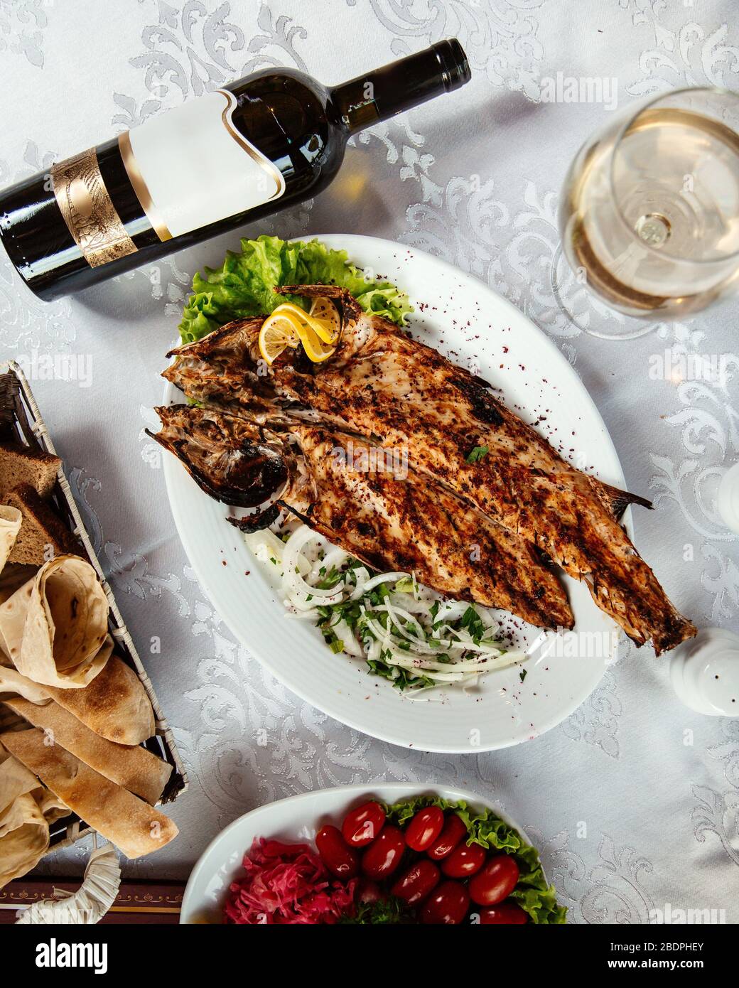 fried fish and bottle of wine Stock Photo