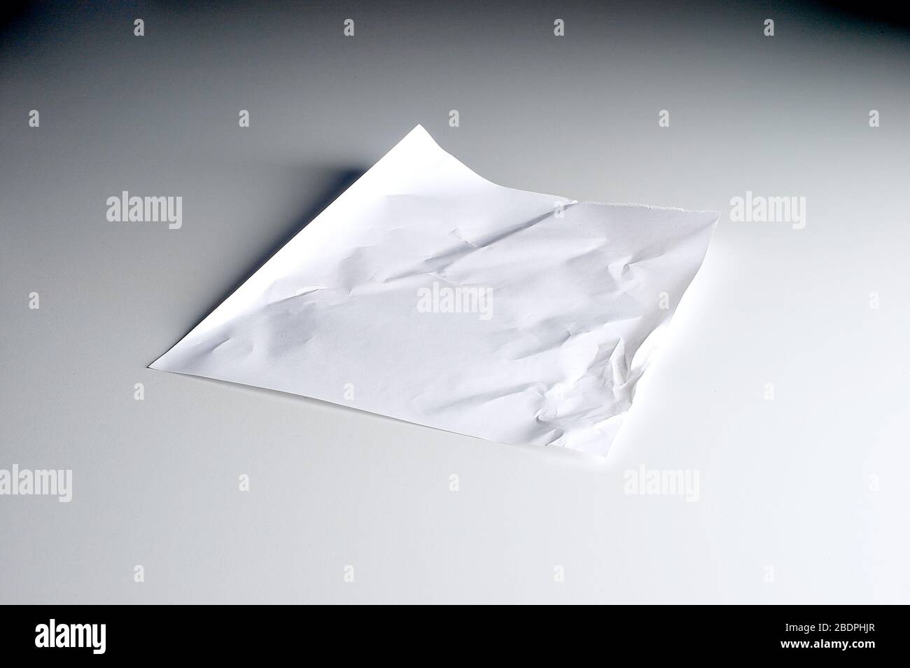 Crumbled paper lying on white background Stock Photo