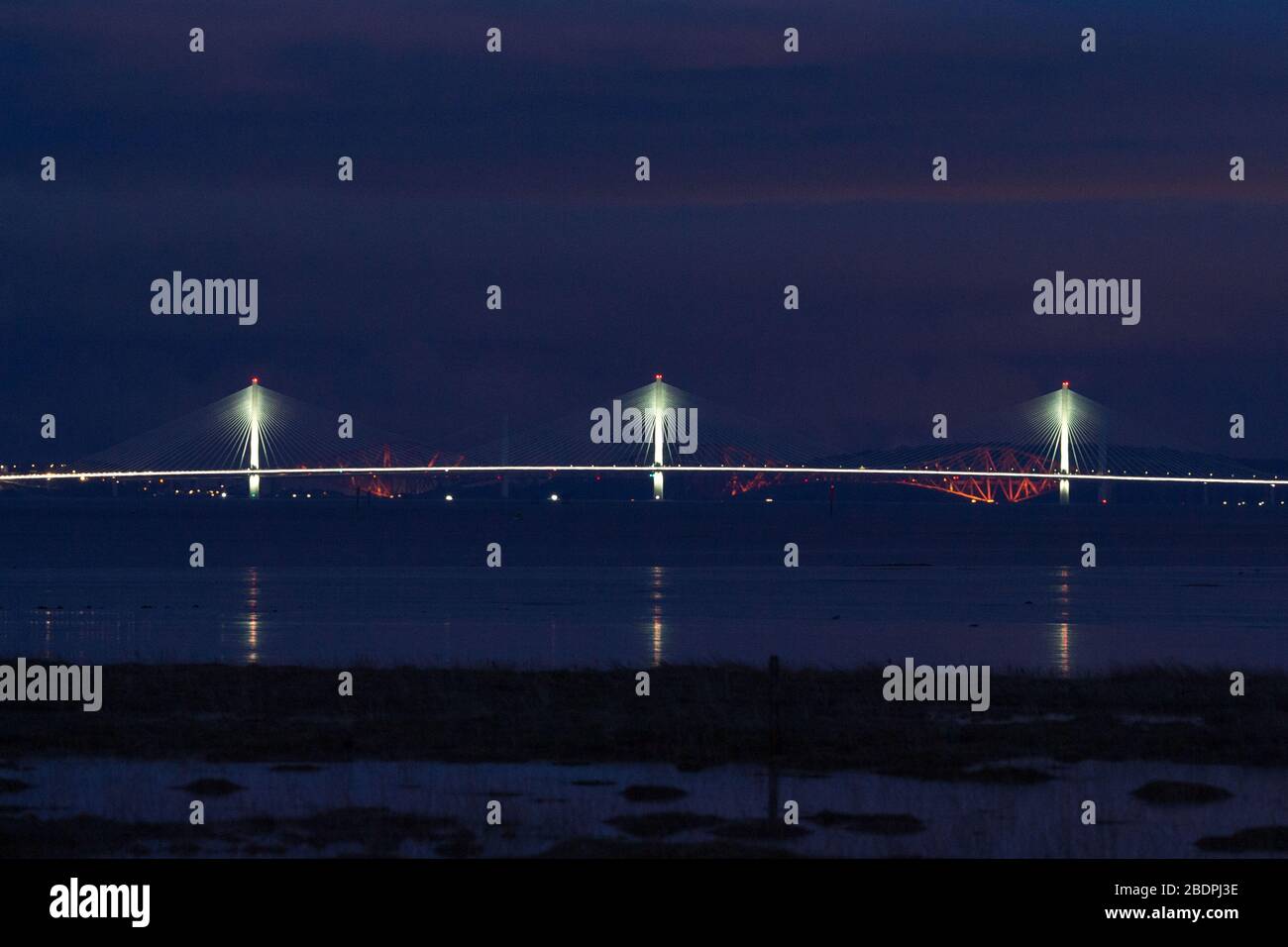 Grangemouth, UK. 8 April 2020.  Pictured: The Queensferry Crossing - Scotland’s newest bridge and the 3rd Firth of Forth crossing which connects Fife and Lothian carrying the M90 Motorway spanning 1.7 miles (2.7km) structure is the longest three-tower, cable-stayed bridge in the world and also by far the largest to feature cables which cross mid-span. This innovative design provides extra strength and stiffness, allowing the towers and the deck to be more slender and elegant. Credit: Colin Fisher/Alamy Live News. Stock Photo