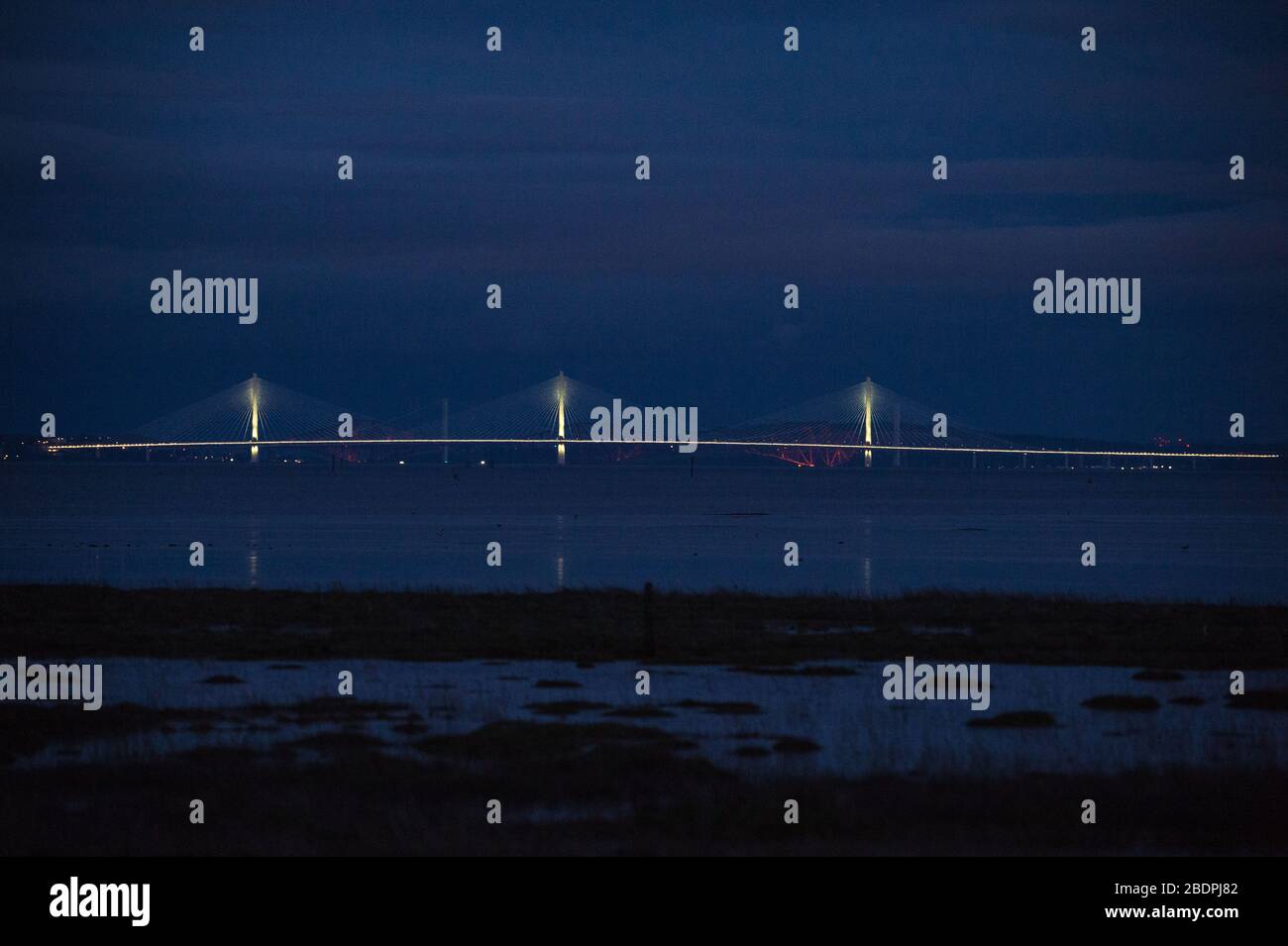 Grangemouth, UK. 8 April 2020.  Pictured: The Queensferry Crossing - Scotland’s newest bridge and the 3rd Firth of Forth crossing which connects Fife and Lothian carrying the M90 Motorway spanning 1.7 miles (2.7km) structure is the longest three-tower, cable-stayed bridge in the world and also by far the largest to feature cables which cross mid-span. This innovative design provides extra strength and stiffness, allowing the towers and the deck to be more slender and elegant. Credit: Colin Fisher/Alamy Live News. Stock Photo