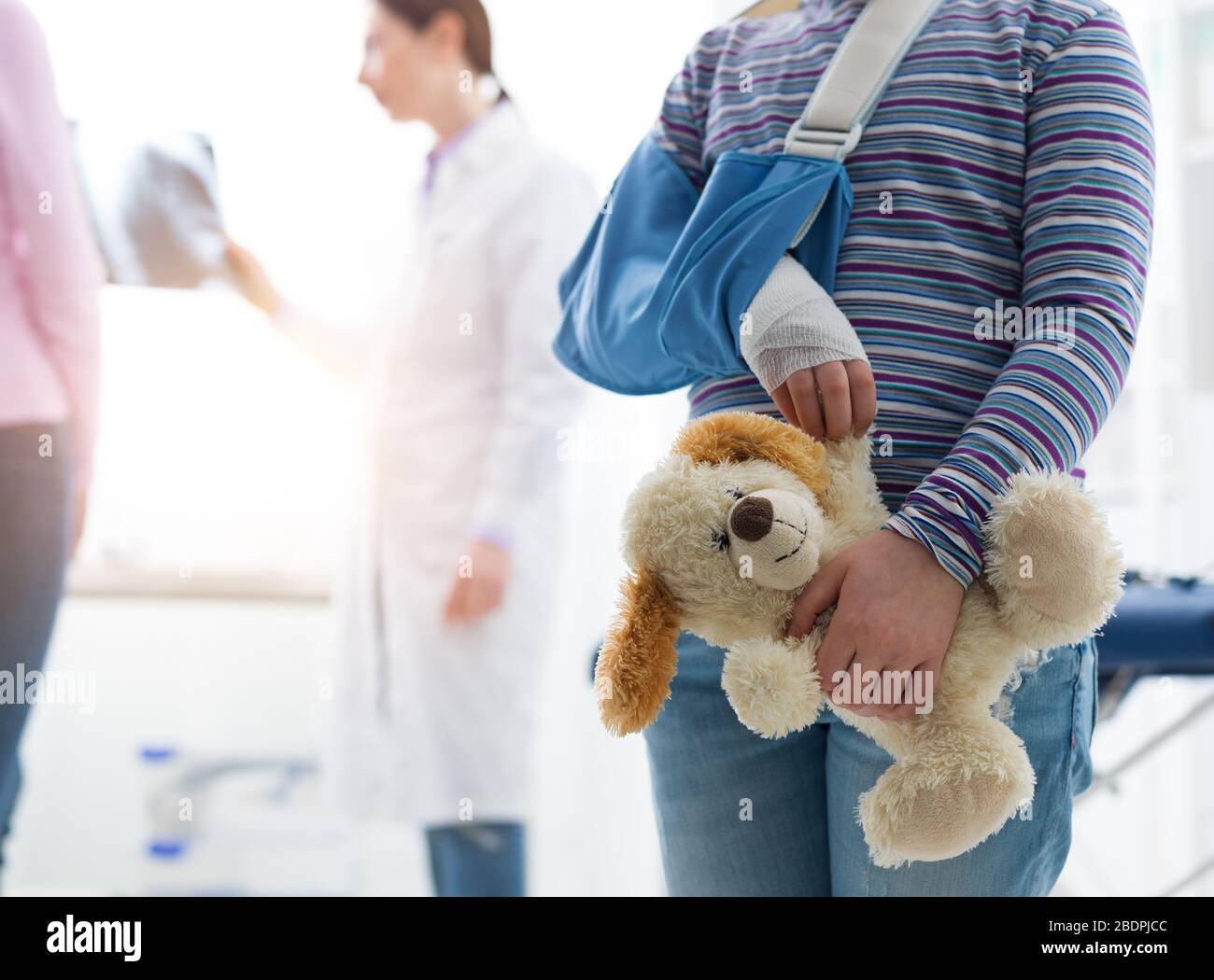 Cute little girl with broken arm in the gypsum with teddy bear