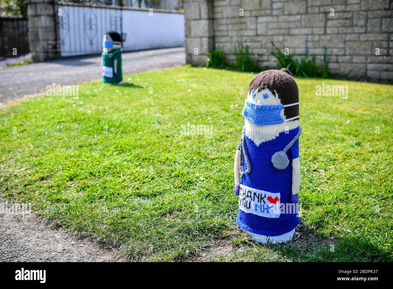 Two knitted NHS doctors are fitted over bollards outside a house in Oldland Common, South Gloucestershire, as the UK continues in lockdown to help curb the spread of the coronavirus. Stock Photo