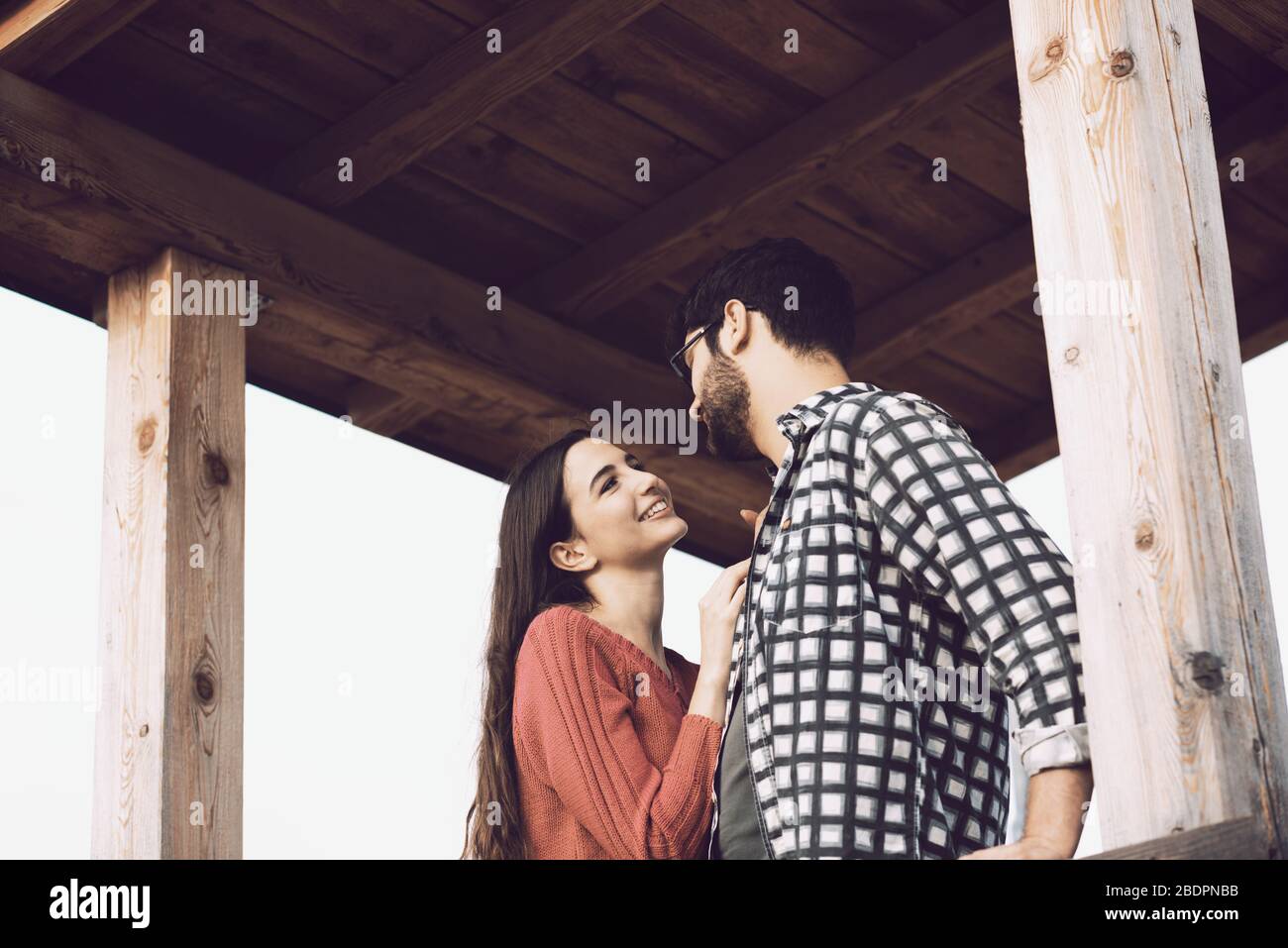 Romantic loving couple staring at each other in a wooden gazebo, feelings and relationships concept Stock Photo