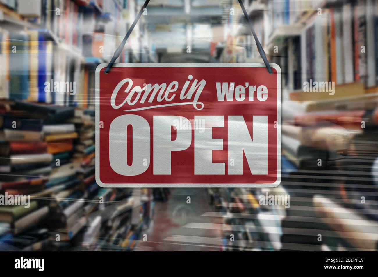 A business sign that says 'Come in We're Open' on a book store window. Stock Photo