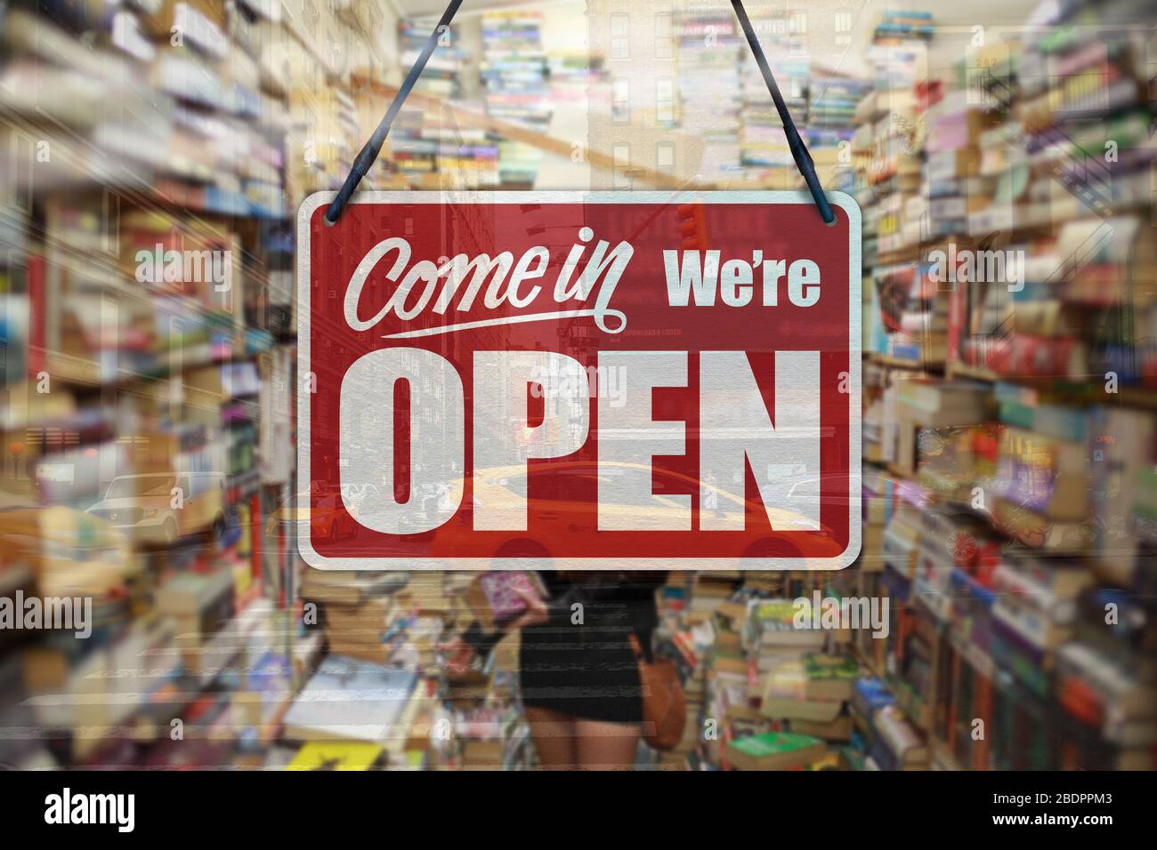 A business sign that says 'Come in We're Open' on a book store window. Stock Photo