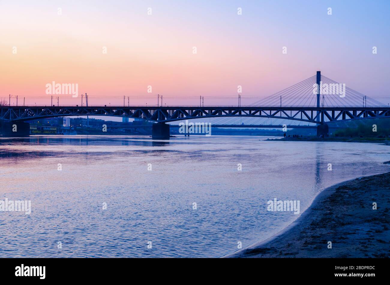 Warsaw Swietokrzyski Bridge over Wisla River at dusk. Stock Photo