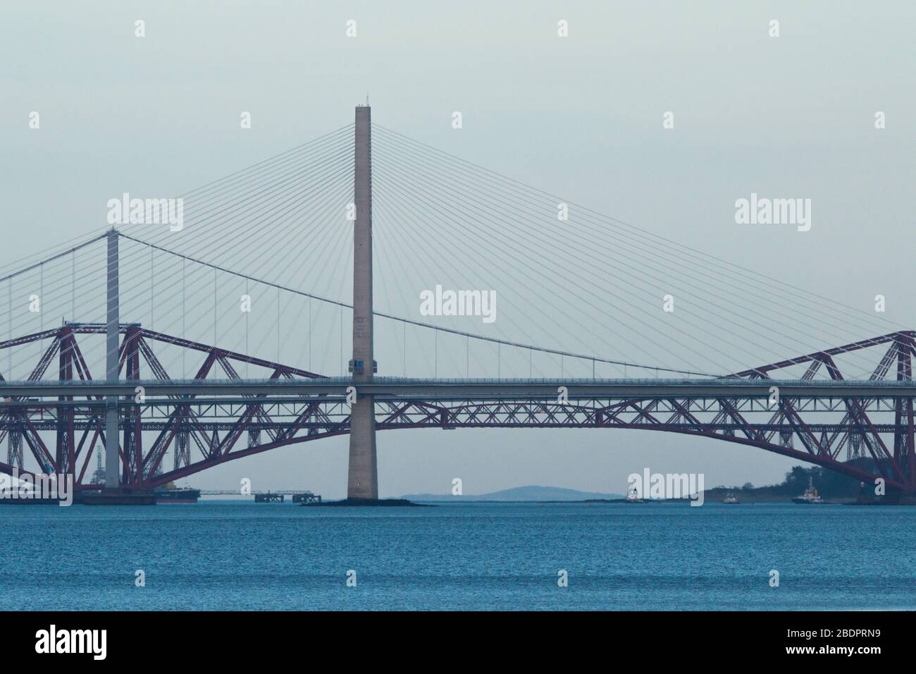 Grangemouth, UK. 8 April 2020.  Pictured: The Queensferry Crossing - Scotland’s newest bridge and the 3rd Firth of Forth crossing which connects Fife and Lothian carrying the M90 Motorway spanning 1.7 miles (2.7km) structure is the longest three-tower, cable-stayed bridge in the world and also by far the largest to feature cables which cross mid-span. This innovative design provides extra strength and stiffness, allowing the towers and the deck to be more slender and elegant. Credit: Colin Fisher/Alamy Live News. Stock Photo