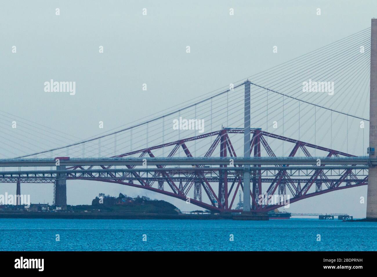 Grangemouth, UK. 8 April 2020.  Pictured: The Queensferry Crossing - Scotland’s newest bridge and the 3rd Firth of Forth crossing which connects Fife and Lothian carrying the M90 Motorway spanning 1.7 miles (2.7km) structure is the longest three-tower, cable-stayed bridge in the world and also by far the largest to feature cables which cross mid-span. This innovative design provides extra strength and stiffness, allowing the towers and the deck to be more slender and elegant. Credit: Colin Fisher/Alamy Live News. Stock Photo